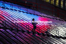 An Air Force cadet is silhouetted by the reflection of the video screen in north stadium as he runs 