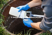 Spencer Perry, graduate student in environmental engineering, takes a wastewater sample from the sew