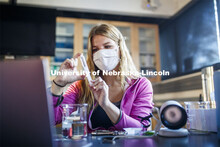 Rachel Anderson, freshman from Harlan, Iowa, creates a vacuum in a syringe of spinach leaf punches t