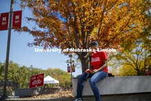 Brianna Rosalez, a freshman from Kansas City, enjoys the sunshine as she checks her phone during the