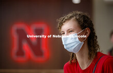 A young woman sits in front of a Nebraska N inside the remodeled Nebraska East Union. East Campus ph