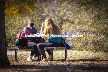 Madyson Hamling (dark blue top) and Emma Arthur study outside the Barkley Memorial Center on a warm 