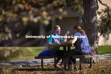 Madyson Hamling (dark blue top) and Emma Arthur study outside the Barkley Memorial Center on a warm 