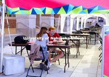 Students study outside of the Nebraska Union under the tents installed to help with social distancin