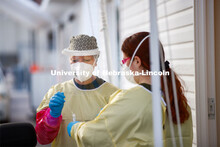 Katie Hibberd, RRT, puts a sample into the tube so it can be tested. Participants in COVID testing a