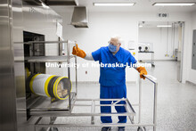 Robert Schmaltz, manager of the Gnotobiotic Mouse Facility, removes a sterilized supply cylinder fro