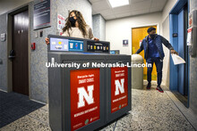Morgan Hartman, project coordinator for recycling services, wheels a new recycling station down the 