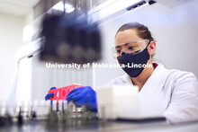 Jessica Calvi, Research Assistant Professor loads saliva sample vials into JANUS a liquid handler wo