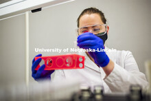 Jessica Calvi, Research Assistant Professor loads saliva sample vials into JANUS a liquid handler wo