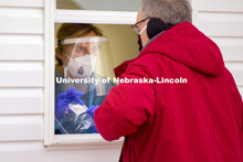 Bria Foley, senior in pre-med and a student worker for the saliva testing, hands the package of vial