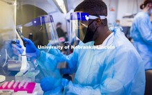 Edwin Owusu transfers saliva samples to other tubes where the saliva will be treated which kills any