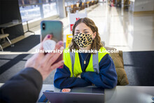 Wellness attendant Katie Lockyear checks the status card as people enter Hawks Hall. Students met th