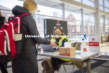 Wellness attendant Katie Lockyear checks the status card as people enter Hawks Hall. Students met th