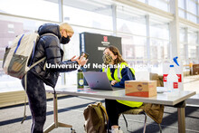 Wellness attendant Katie Lockyear checks the status card as people enter Hawks Hall. Students met th