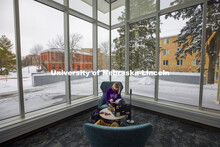 Lydia Cole, a senior from Plattsmouth, NE, studies in the corner seat ner the windows of the Dinsdal
