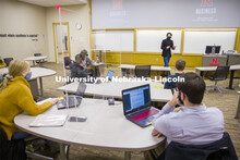 Students separated by plexiglass listen in a classroom as Roberto Stein teaches FINA 475 - Strategic