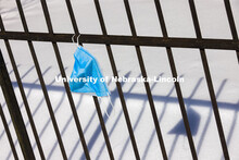 A lonely, discarded mask hangs off a fence along R Street. February 19, 2021. 