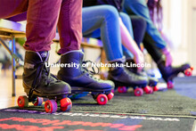 Students put on their pair of rollerblades before skating during the Club 80 Roller Skating Event in