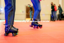 Students begin skating in a circle during the Club 80 Roller Skating Event in the Nebraska Union Bal