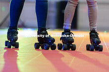 Light shines behind two skaters during the Club 80 Roller Skating Event in the Nebraska Union Ballro