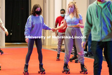 Students hold hands as they skate during the Club 80 Roller Skating Event in the Nebraska Union Ball