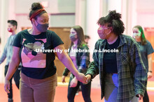 Students hold hands as they skate during the Club 80 Roller Skating Event in the Nebraska Union Ball