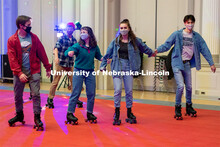 Students hold hands as they skate during the Club 80 Roller Skating Event in the Nebraska Union Ball