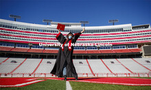 Macy Behrens, senior in advertising and public relations and also graphic design, poses in regalia t