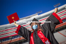 Macy Behrens, senior in advertising and public relations and also graphic design, poses in regalia t