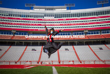 Macy Behrens, senior in advertising and public relations and also graphic design, poses in regalia t