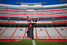 Macy Behrens, senior in advertising and public relations and also graphic design, poses in regalia t
