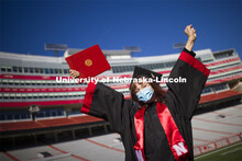 Macy Behrens, senior in advertising and public relations and also graphic design, poses in regalia t