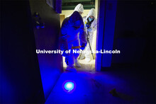 Symone Arends, a senior from Lincoln, shines an ultraviolet light onto the floor. The light will mak