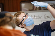Tyler Rinn checks the recycle mark on a cup lid. Environmental Studies Orientation students work on 
