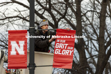 Drew Ehrisman, Construction Supervisor with Landscape Services, slides one of the new banners onto a