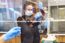 In a hands-on chemistry experiment Ruby Kulovitz and her lab partners are all reflected in the plexi