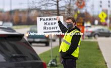 Noah Schwendeman, Student Support Specialist with Husker Hub, directs traffic along Pinnacle Arena D