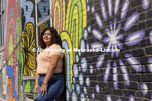 Josselyn Catalan, junior in global studies and ethnic studies, poses by a mural in an alleyway of th