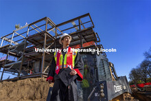 Yajyoo Shrestha, a graduating senior in civil engineering, stands before the construction site of th