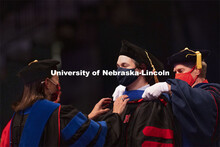 Colton Fruhling is hooded by his mother, Professor Ann Fruhling. Colton received his doctoral of phi