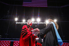 Chancellor Ronnie Green wears gloves to hand each graduate including Misty Sue Pocwierz-Gaines their