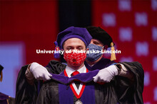 Samuel Baue receives his hood during College of Law Graduation at Pinnacle Bank Arena. May 7, 2021. 