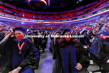 Samuel Baue, left, and Anna Bauerie move their tassels on their tams following graduations. College 