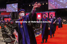 Curtis Fuller waves to family and friends as the graduates process out of the arena. College of Law 