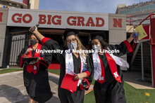 Claire Wiens and Adrienne McDowell cheer as they step on the field Saturday morning. UNL Commencemen