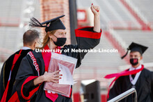 Chancellor’s Scholar Lauren Niesen gestures to family and friends after receiving her diplomas.  A