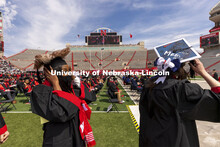 Aubryanna Cooper-Wilborn and Robin Coleman hang on to their mortar boards as they proceed to receive