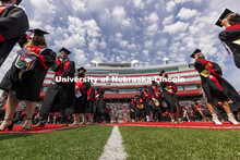 Students line up in the center of the field to receive their diplomas. UNL Commencement in Memorial 