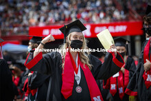 Lauren Leapley gestures to a friend as she processes to receive her College of Business diploma. UNL
