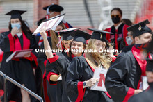 Addie Schwartzman waves to family and friends after receiving her diploma. UNL Commencement in Memor